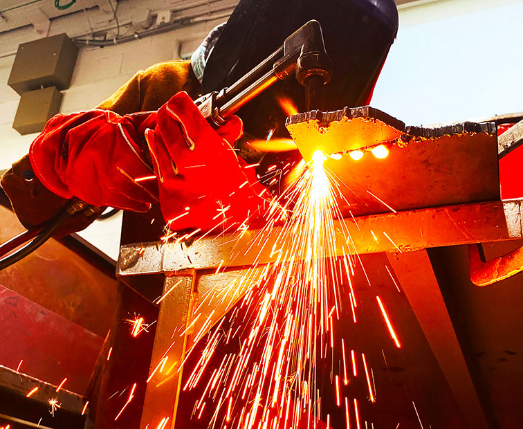 student cutting metal with a torch